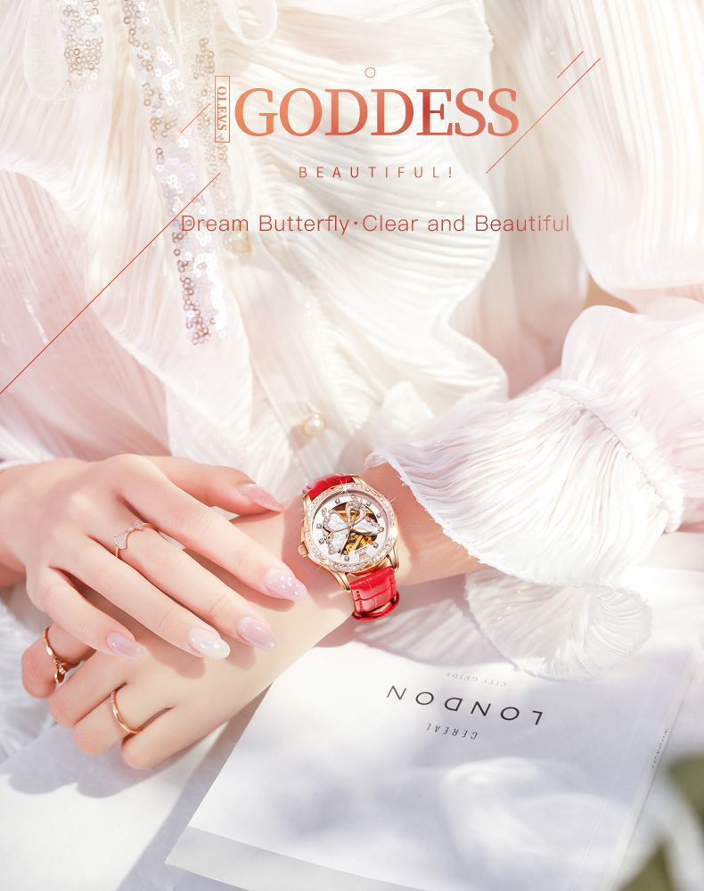 Watch with red strap on wrist, white fabric background, 'Goddess' text overlay