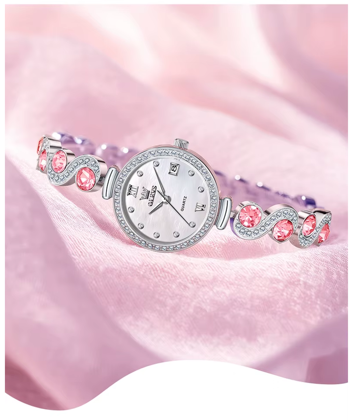 Silver watch with pink gemstones on a pink fabric background